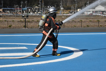 放水活動する装備した隊員１人を右横から撮影